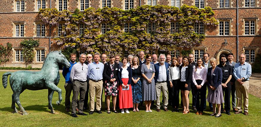 Attendees of symposium standing in front of Jesus College