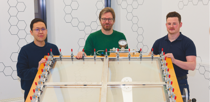 Ariffin, Erwin and Shaun stand behind the solar reactor.