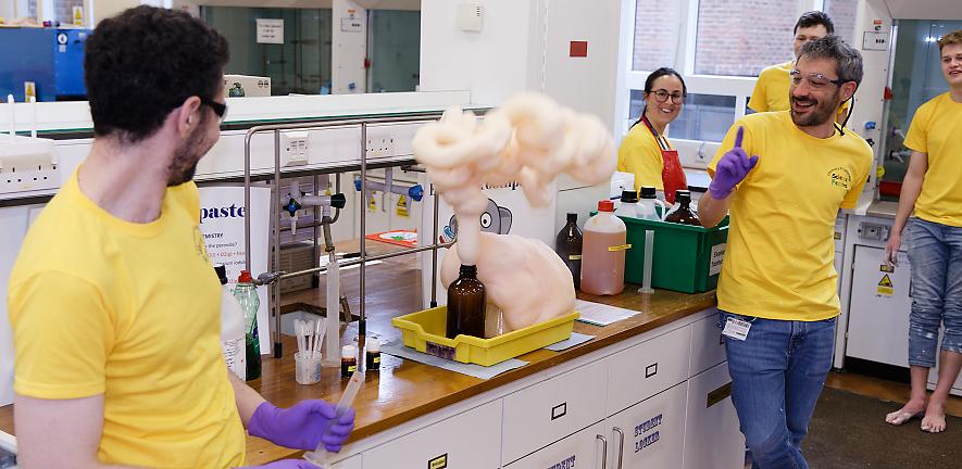 Volunteers in the lab with foamy stuff coming out of bottle