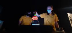 Two volunteers holding a tube filled with bright liquids