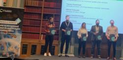A group of five prizewinners on the stage at the Symposium