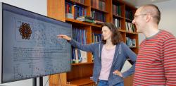 Dr Julia Schumann and Professor Angelos Michaelides looking at figures on whiteboard.