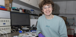 James in his lab smiling at camera