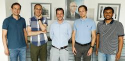 Christoph, Angelos, Stephen, Daniel, and Venkat stand in the Todd Hamied lecture theatre.