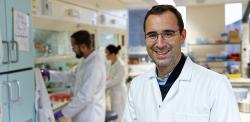 Bernardes in white lab coat in his lab
