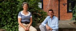 Two people sit on garden steps