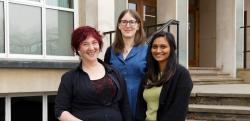 Three women stand on the front steps of the chemistry department.