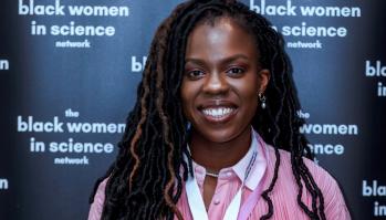 A woman in front of a sign that says the black women in science network