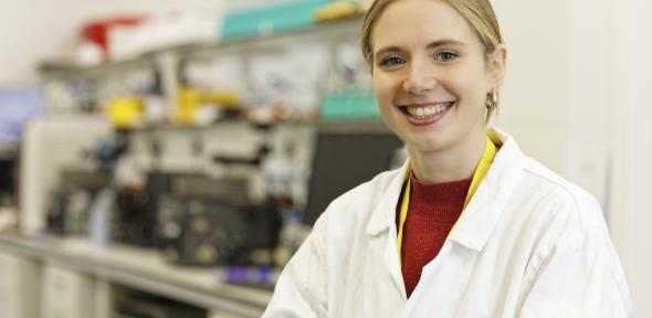 Libby Brown in a lab coat in the laboratory.