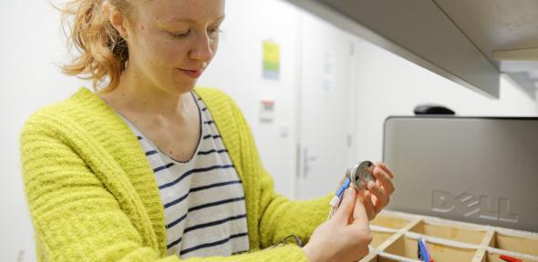 Alice Merryweather wearing yellow cardigan working on wiring