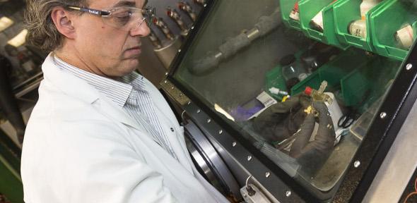 Professor Dominic Wright in lab coat at scientific instrument