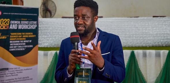 David Izuogo holding a microphone and speaking