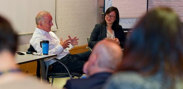 Professor John Pyle sitting in chair next to Jenny Zhang at front of lecture theatre