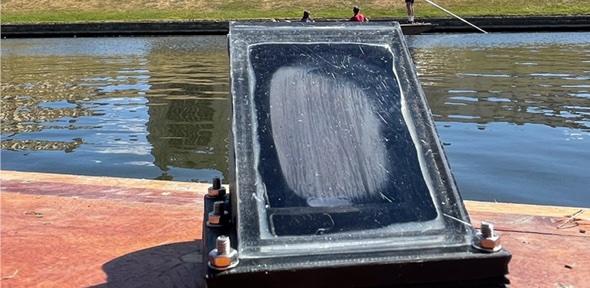 The artificial leaf on a punt on the Cam with punters in the background