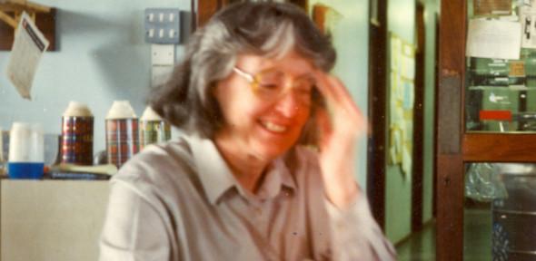A middle-aged Mary McPartlin smiling and adjusting her glasses
