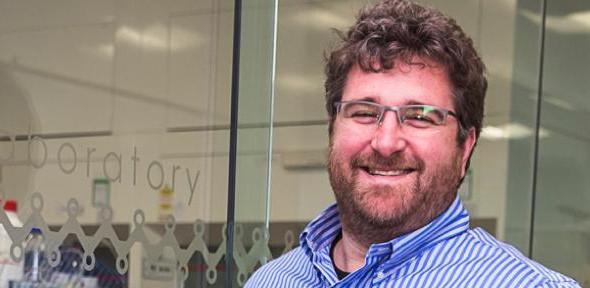 Head and shoulders of Professor Oren Scherman wearing blue shirt looking at camera