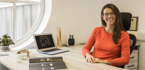 Professor Silvia Vignolini sitting at desk and smiling at camera