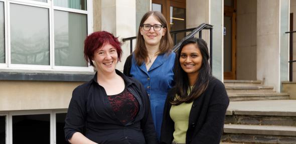 Three women stand on the front steps of the chemistry department.