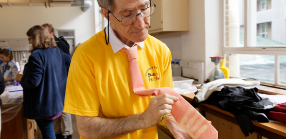 Prof Stuart Clarke holding a thermal tie that has changed colour when warmed by his hand