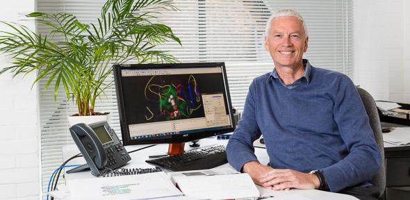 Robert Glen sitting at desk smiling at camera