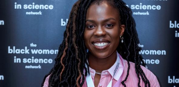 A woman in front of a sign that says the black women in science network