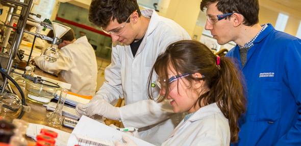 Students wearing lab coats in the teaching lab