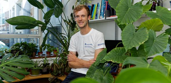 Alex Forse (centre) and green plants.