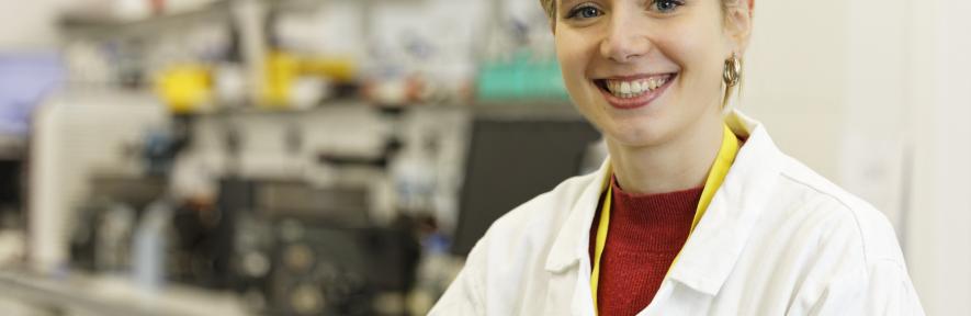 Libby Brown in a lab coat in the laboratory.