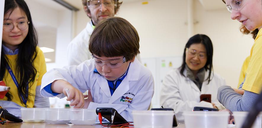 young boy involved with an experiment at open day