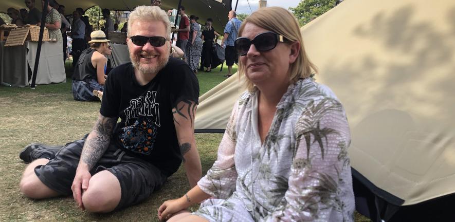 Two staff members sitting in front of tent in Botanic Gardens