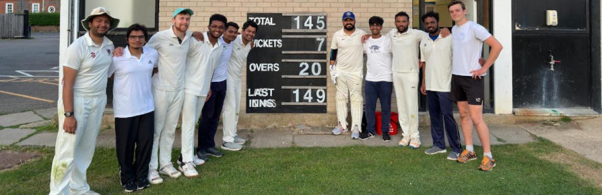 Department cricket team members around scoreboard showing they beat Molecular Biology by 3 runs