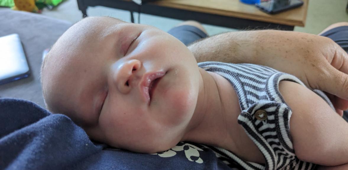 Sleeping baby lying on someone's chest