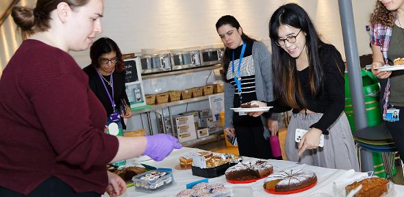 People serving cake at the Macmillan coffee morning