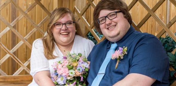 Jasmine and Ryan in wedding clothes smiling at camera