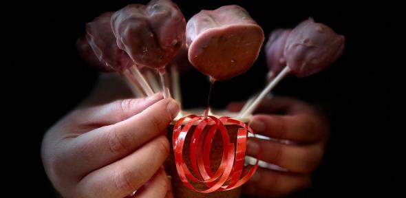 Cake pops in a cup being held by a hand