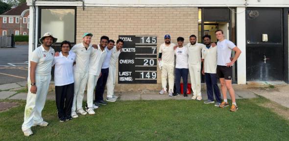 Department cricket team members around scoreboard showing they beat Molecular Biology by 3 runs