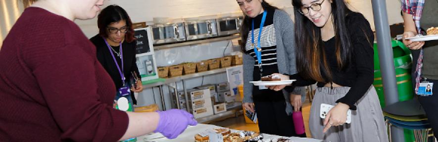 People serving cake at the Macmillan coffee morning