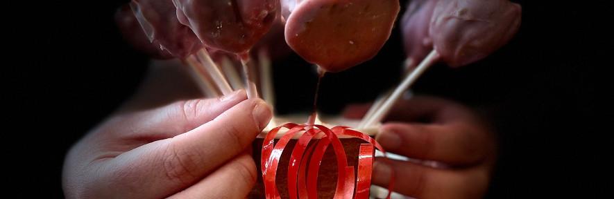 Cake pops in a cup being held by a hand